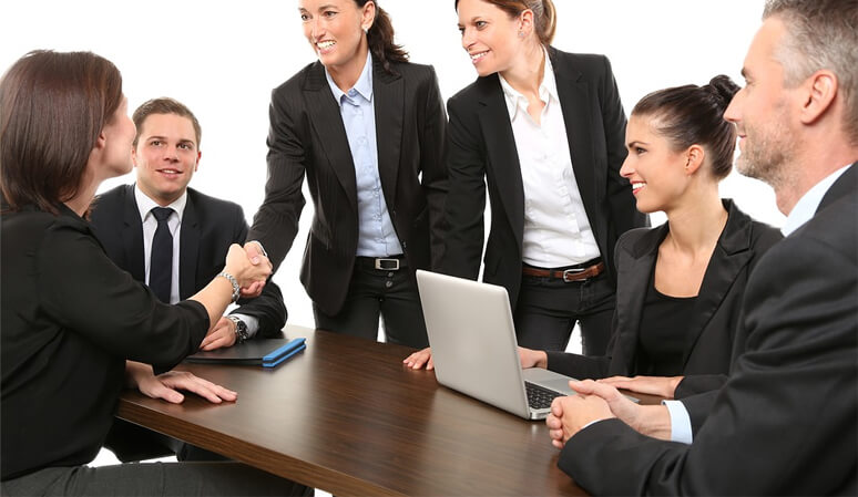 A group of business people are gathered around a table.